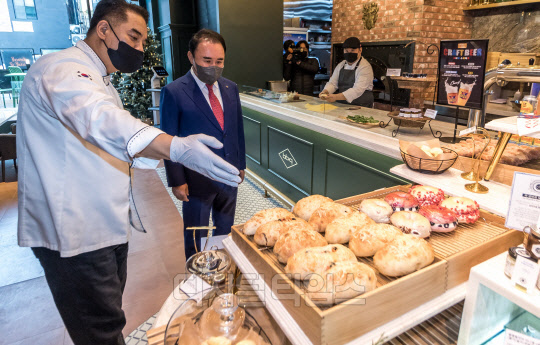 윤홍근 제너시스BBQ 회장이 6일 서울 송파구 'BBQ 빌리지(BBQ Village)' 송리단길점에서 열린 오픈행사에 참석해 관계자 설명을 들으며 매장을 살펴보고 있다. 박동욱기자 fufus@